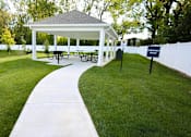 Thumbnail 2 of 15 - A white gazebo with a walkway leading to it.