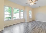 Thumbnail 7 of 12 - an empty living room with wood floors and a ceiling fan