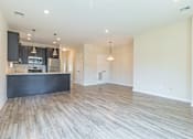 Thumbnail 6 of 12 - an open kitchen and living room with wood flooring