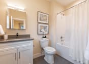 Thumbnail 7 of 31 - A white bathroom with a toilet, sink, and shower.
