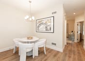 Thumbnail 11 of 31 - A dining room with a white table and chairs.