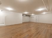 Thumbnail 15 of 31 - A large empty room with wooden floors and white walls.