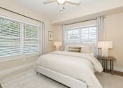 Thumbnail 24 of 31 - A bedroom with a large bed and a ceiling fan.