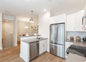 Thumbnail 19 of 31 - A modern kitchen with stainless steel appliances and white cabinets.