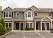 Thumbnail 3 of 12 - a house with a parking lot in front of it