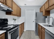 Thumbnail 8 of 28 - a kitchen with wooden cabinets and stainless steel appliances at Stonewater Apartments, Louisville, 40241