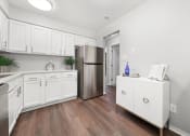 Thumbnail 1 of 14 - a kitchen with white cabinets and a stainless steel refrigerator at Hampton in Highland Apartments, Highland, IN, 46322