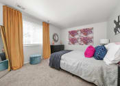 Thumbnail 5 of 14 - a bedroom with a bed and a window with orange curtains at Hampton in Highland Apartments, Indiana, 46322