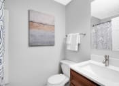 Thumbnail 15 of 28 - a bathroom with a toilet sink and mirror at Stonewater Apartments, Kentucky