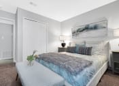 Thumbnail 11 of 28 - a bedroom with a bed and a nightstand with a vase of flowers on it at Stonewater Apartments, Louisville, KY