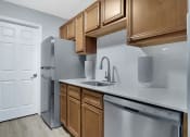 Thumbnail 9 of 28 - a kitchen with wooden cabinets and stainless steel appliances at Stonewater Apartments, Kentucky