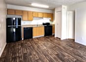 Thumbnail 12 of 20 - a kitchen with black appliances and wood laminate flooring