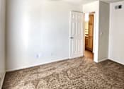 Thumbnail 8 of 20 - a bedroom with a carpeted floor and a door to a bathroom