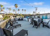 Thumbnail 49 of 64 - Deck with BBQ and seating at Ocean Breeze Terrace Apartment, Huntington Beach, CA