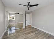 Thumbnail 10 of 64 - an empty living room with a ceiling fan and a window at Ocean Breeze Terrace Apartment, California, 92648