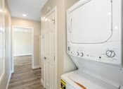 Thumbnail 6 of 10 - a laundry room with a washer and dryer and a hallway with a door at Huntington Manor Homes Apartment, California, 92648