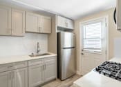 Thumbnail 4 of 10 - a kitchen with white cabinets and a stainless steel refrigerator at Huntington Manor Homes Apartment, Huntington Beach, 92648