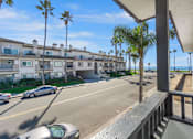 Thumbnail 15 of 64 - the view of the street from the balcony of an apartment building with palm trees at Ocean Breeze Terrace Apartment, Huntington Beach
