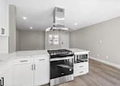 Thumbnail 20 of 64 - a kitchen with white cabinets and a stove and a hood at Ocean Breeze Terrace Apartment, Huntington Beach, CA, 92648