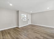 Thumbnail 25 of 64 - the living room of a new home with white walls and wood floors at Ocean Breeze Terrace Apartment, Huntington Beach, CA