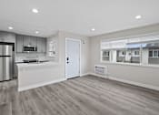 Thumbnail 3 of 14 - an empty kitchen and living room with a refrigerator and a sink at Charle Square Apartments, Costa Mesa, California