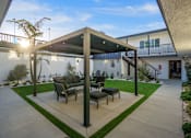 Thumbnail 29 of 64 - A patio with a table and chairs under a roof at Ocean Breeze Terrace Apartment, Huntington Beach, 92648