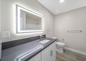 Thumbnail 4 of 18 - a bathroom with a large mirror and a sink and a toilet at Wescove Apartments, West Covina
