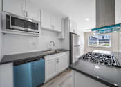 Thumbnail 3 of 18 - a modern kitchen with white cabinets and stainless steel appliances at Wescove Apartments, West Covina, 91790