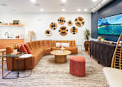 Thumbnail 15 of 34 - A living room with a brown sofa, a coffee table, and a TV on the wall. at The Reserve La Mirada, La Mirada, 90638