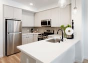 Thumbnail 2 of 34 - A modern kitchen with a stainless steel refrigerator and a white countertop. at The Reserve La Mirada, La Mirada, California