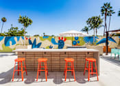 Thumbnail 18 of 34 - A bar with orange stools in front of a wall with a mural. at The Reserve La Mirada, California, 90638