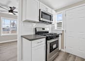 Thumbnail 2 of 10 - a kitchen with a stove and a microwave at Huntington Manor Homes Apartment, Huntington Beach