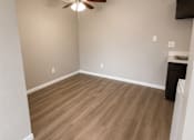 Thumbnail 17 of 38 - A room with a ceiling fan and wooden flooring.