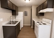 Thumbnail 15 of 38 - A kitchen with brown cabinets and a white stove.