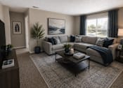 Thumbnail 1 of 38 - A living room with a grey couch, a coffee table, and a painting on the wall.