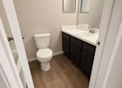 Thumbnail 28 of 38 - A white toilet sits in a bathroom next to a sink.