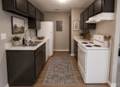 Thumbnail 3 of 38 - A kitchen with white appliances and dark brown cabinets.
