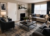 Thumbnail 5 of 38 - A living room with a fireplace, two couches, and a coffee table.