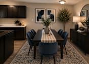 Thumbnail 6 of 38 - A dining room with a table surrounded by chairs and a plant on the table.