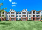 Thumbnail 14 of 16 - A large apartment complex with a green lawn in front at Addison Park Apartments in Arlington, TX.