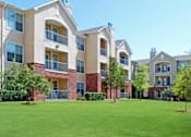 Thumbnail 13 of 16 - Apartment complex with green grass in front at Addison Park Apartments in Arlington, TX.