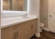 Thumbnail 29 of 52 - A bathroom with a white counter top and wooden cabinets.