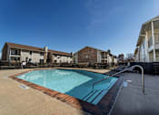 Thumbnail 32 of 38 - Swimming pool with sundeck and lounge chairs at The Finley Apartments, Dallas, Texas