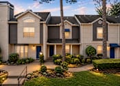 Thumbnail 43 of 52 - A well-lit residential building with a front yard and a tree.