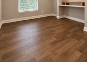 Thumbnail 23 of 52 - A room with wooden floors and a window with blinds.