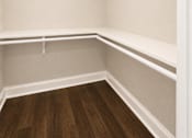 Thumbnail 31 of 52 - Empty walk-in closet with white shelves and wooden floors.