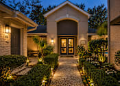 Thumbnail 38 of 52 - A house with a lit pathway leading to the front door.