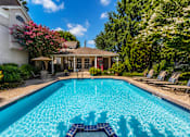 Thumbnail 34 of 52 - A swimming pool in a backyard with a house and trees in the background.