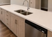 Thumbnail 27 of 52 - A modern kitchen with a stainless steel dishwasher and wooden cabinets.