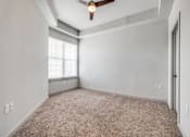 Thumbnail 80 of 128 - A room with a ceiling fan and carpeted floor.